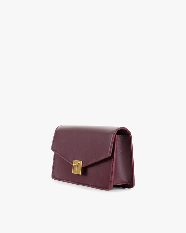 Sac ELEANOR Aubergine vu de trois-quarts, fermoir Marble Arch doré, posé de côté