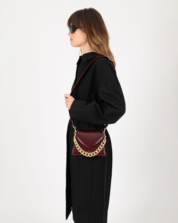 Sac GABRIELLE Mahogany porté en bandoulière, vue de profil, chaîne dorée détachable sur le rabat
