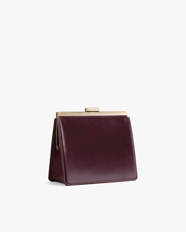 JEANNE bag in Mahogany, side view, standing, closed gold metal clasp, no strap visible