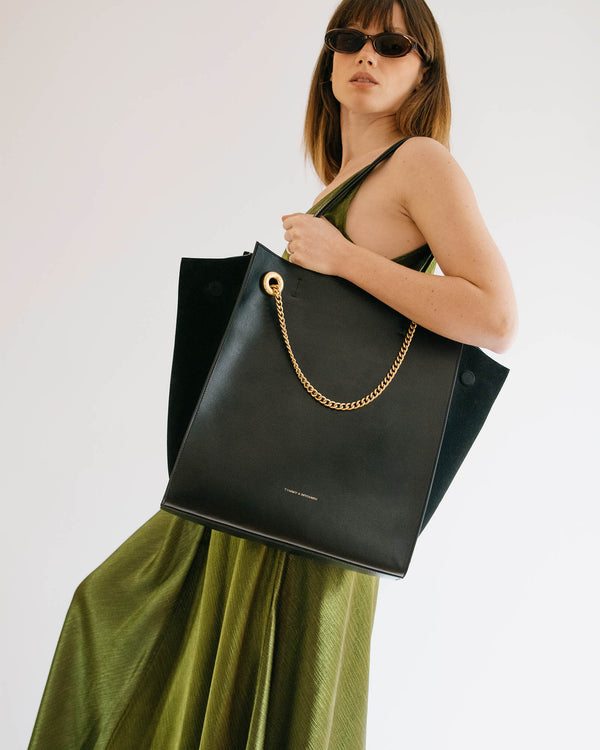 Cabas LEXI GM noir porté à l'épaule, chaîne amovible dorée, panneaux en suède et cuir