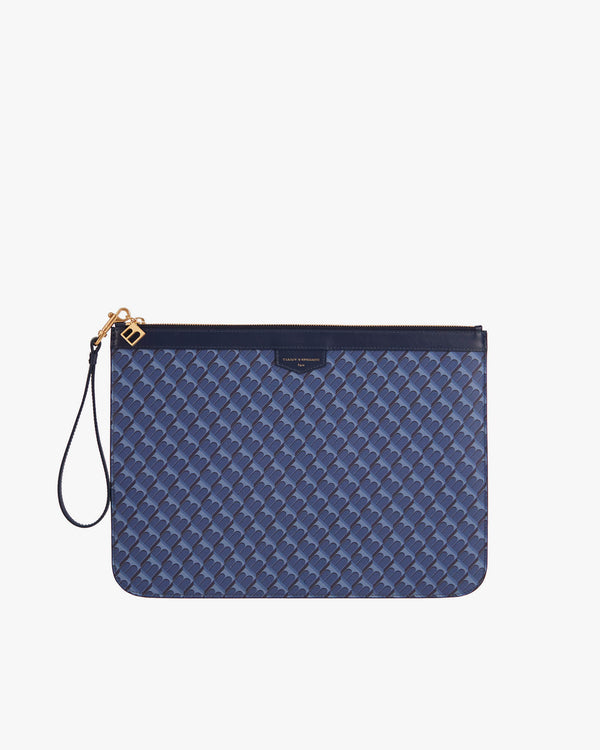 Pochette GM Monogram bleue, vue de face, dragonne en cuir détachée posée à gauche, fermeture zippée