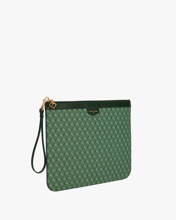 Pochette GM Monogram verte de trois quarts, dragonne en cuir détachée, posée debout