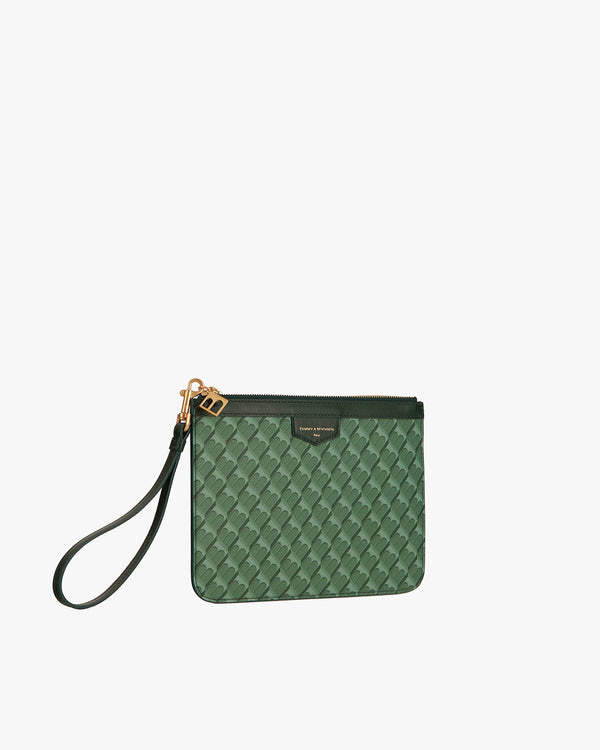 Pochette PM Monogram verte de trois quarts, dragonne en cuir sortie, motif Marble Arch visible