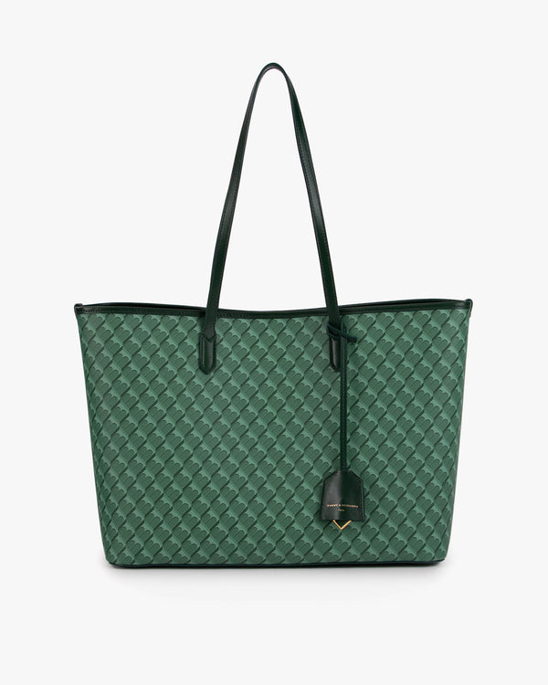 Sac TOTE MONOGRAM vert de face, posé, motif architecte sur toile enduite et anses plates en cuir