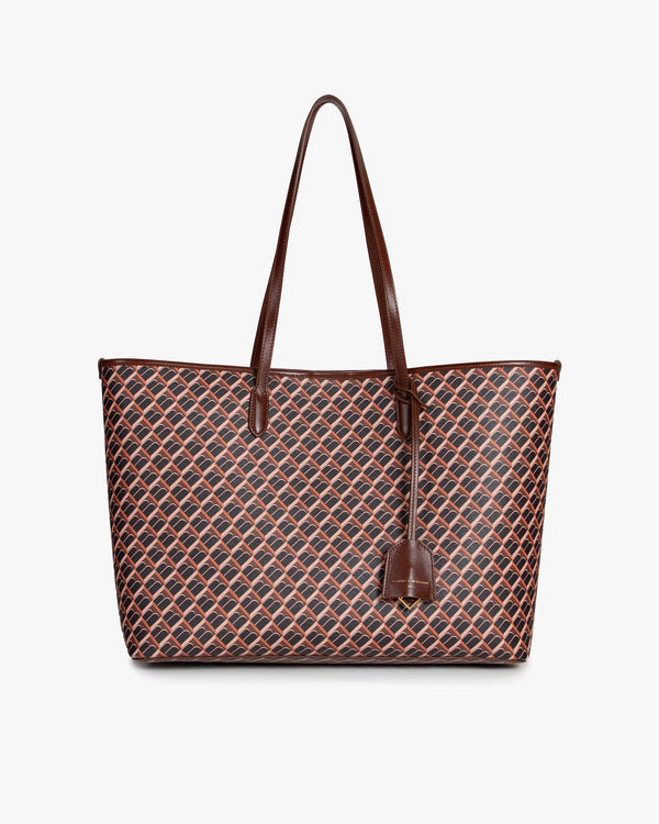 TOTE MONOGRAM brun, vue de face, posé, anses longues en cuir et étiquette suspendue visibles
