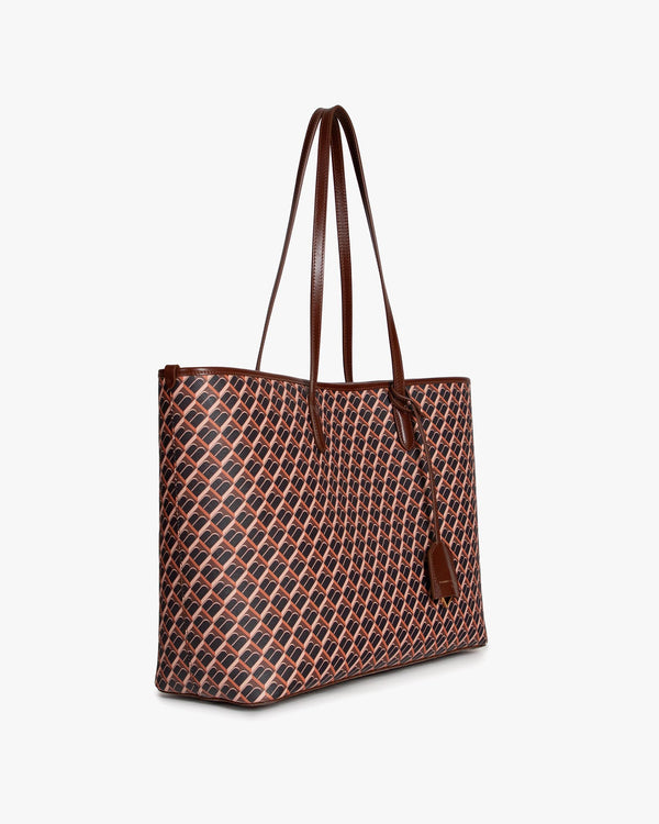 TOTE MONOGRAM brun, vue de profil, porté à l'épaule par ses anses en cuir