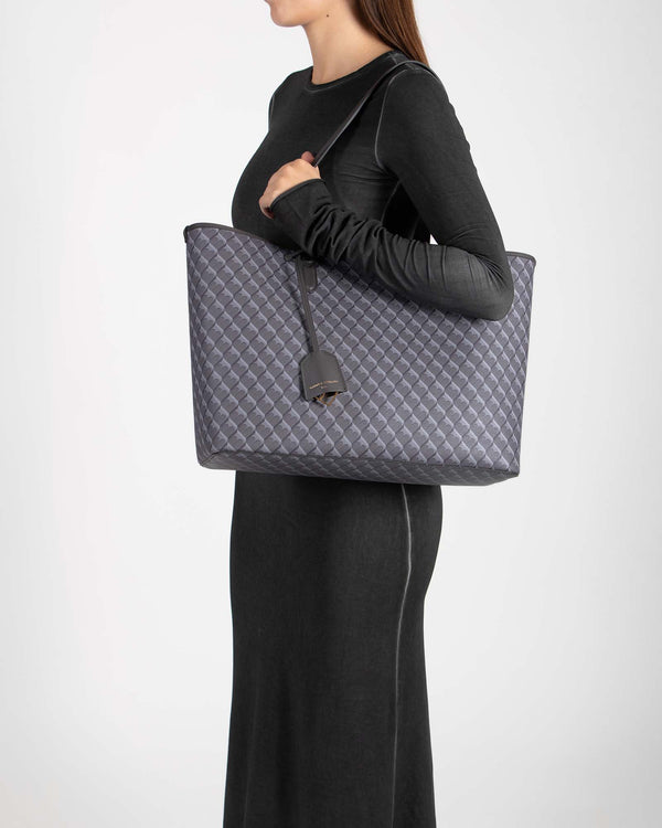 TOTE MONOGRAM gris porté à l'épaule, vue de profil sur mannequin, anse plate en cuir