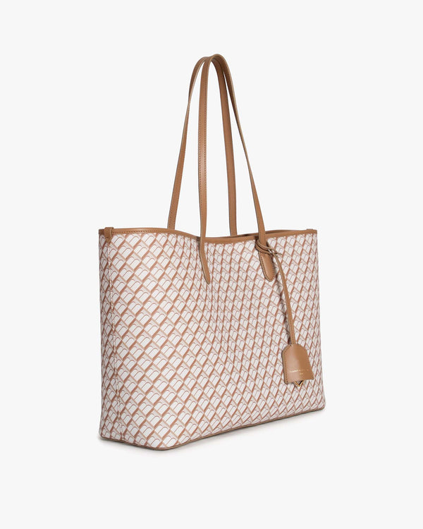 TOTE MONOGRAM Tan, vue de trois quarts, sac posé, anses en cuir et toile à motif monogramme