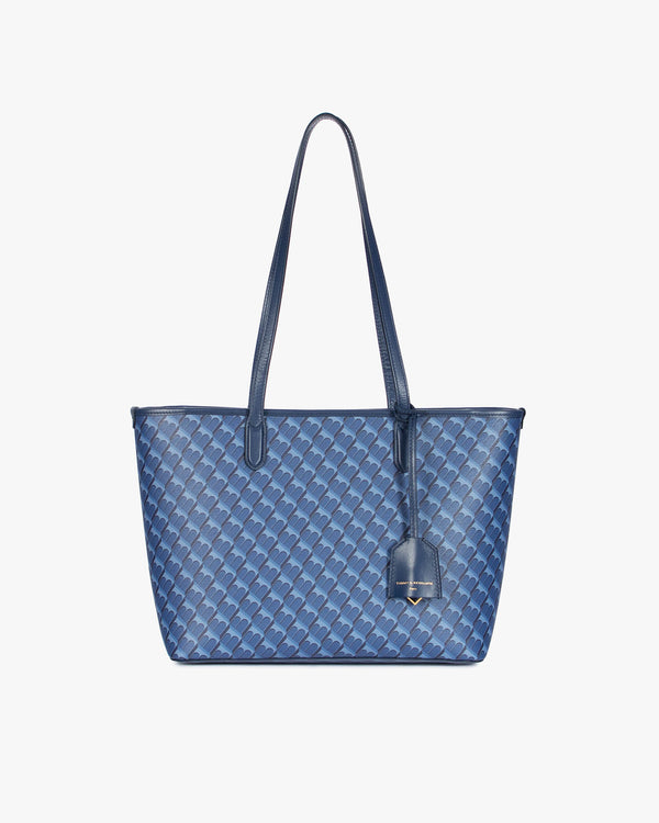 TOTE MONOGRAM PM bleu, vue de face, posé, anses hautes et porte-adresse en cuir
