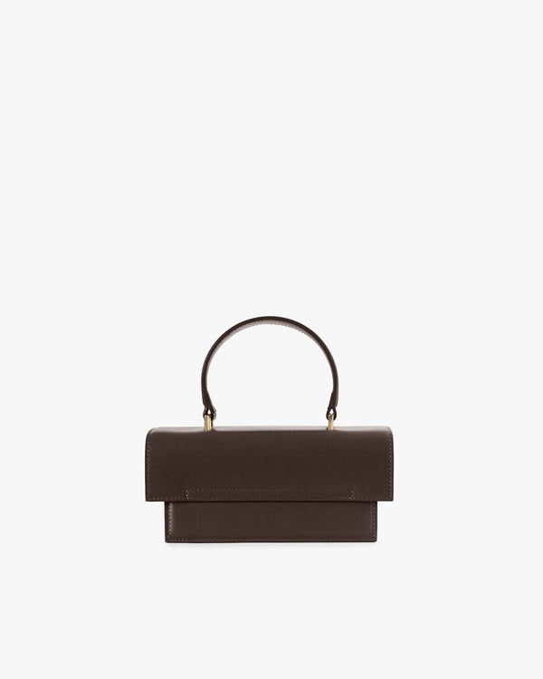 Sac THEA MINI chocolat de face, posé, avec poignée arrondie et rabat oversize