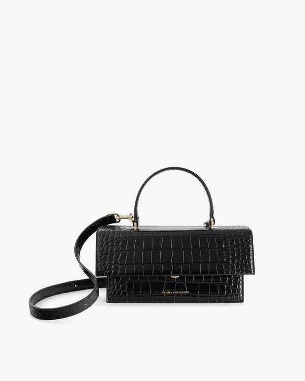 Sac THEA Noir - Embossé Crocodile de face, poignée rigide et bandoulière détachée, posé