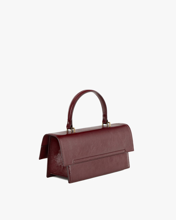 Sac THEA en naplak bordeaux, vue de trois-quarts arrière, poignée rigide et rabat oversize
