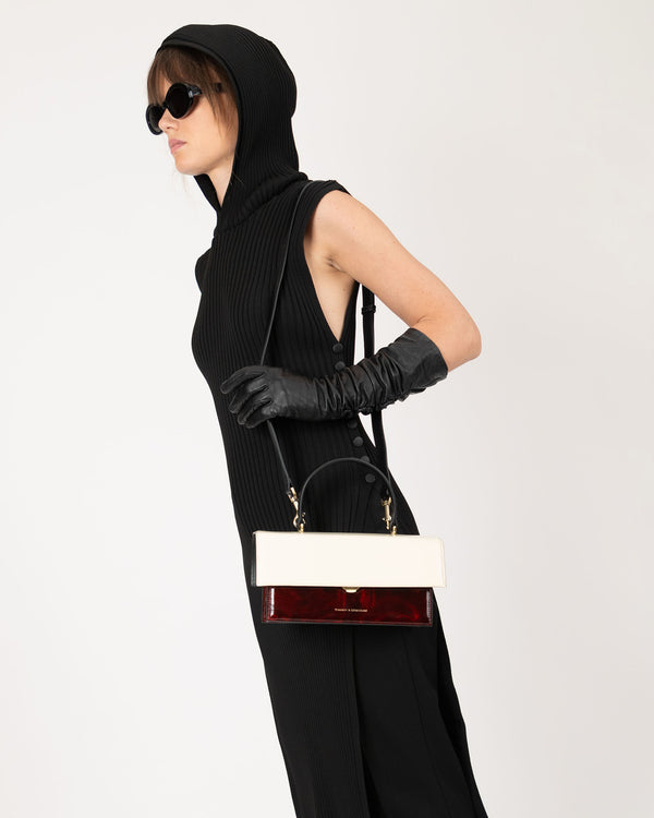 Sac THEA colourblock art déco porté en bandoulière, vue de profil sur modèle, poignée rigide visible