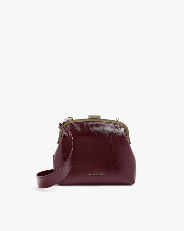 EMMA bag in bordeaux naplak, front view, standing, with long detachable strap and gold clasp
