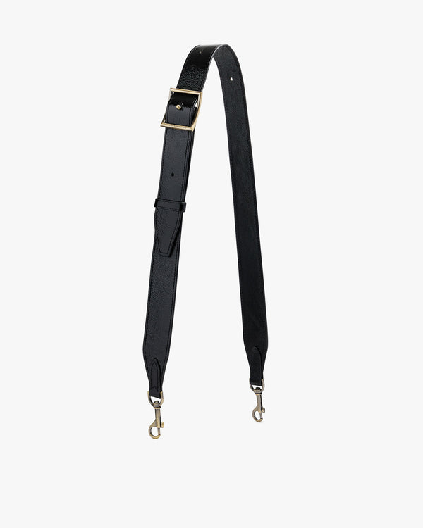 Bandoulière ajustable large en cuir naplak noir, posée à plat, boucle et mousquetons apparents