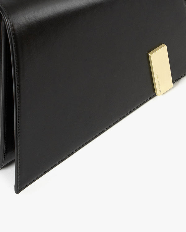 TARA bag in black, close-up on the flap and rectangular gold clasp