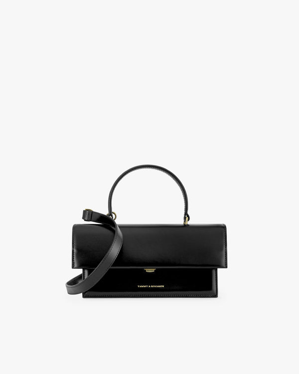 Sac THEA en cuir noir, vue de face, rabat fermé, poignée rigide et bandoulière amovible