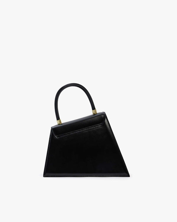 Sac CUBIST noir, vue de face, silhouette trapézoïdale asymétrique, anse ronde et fermoirs dorés