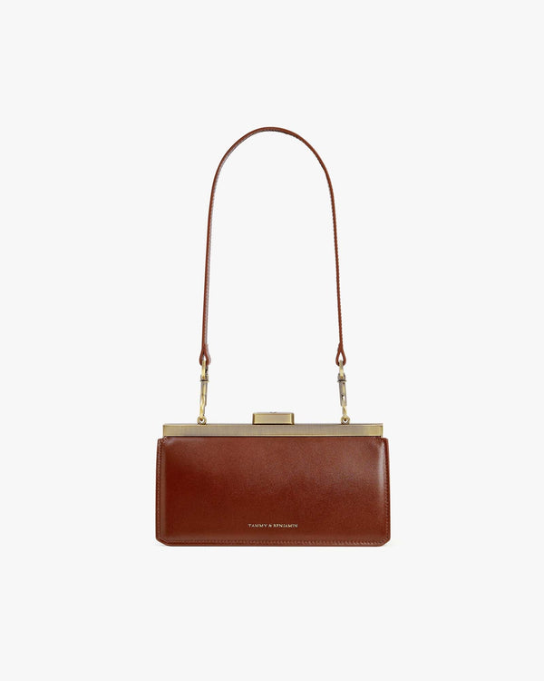 Sac JEANNE BAGUETTE brun, vue de face, porté à l'épaule avec anse longue, fermoir doré fermé