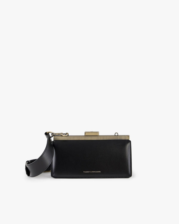 Sac JEANNE BAGUETTE noir de face, fermoir rétro doré, porté avec anse bandoulière