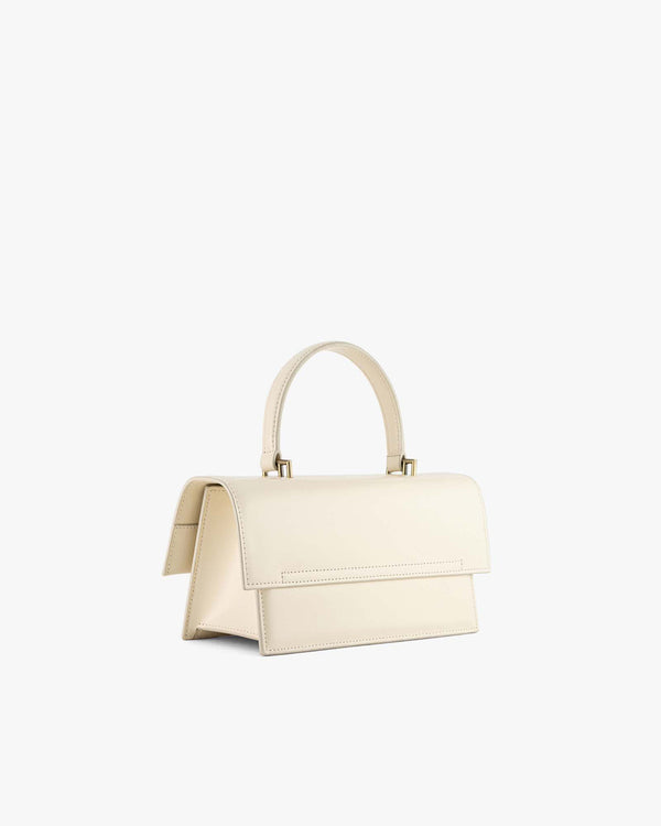 Sac THEA Ivoire vu de trois quarts arrière, rabat fermé, poignée rigide et attaches dorées