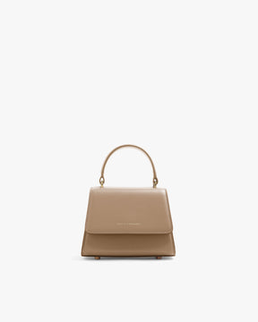 Sac ALEXIA NANO beige de face, rabat fermé, poignée rigide, posé sur fond blanc