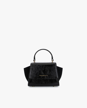 ALEXIA NANO bag in black naplak, front view, top handle, side wings and flap closure visible
