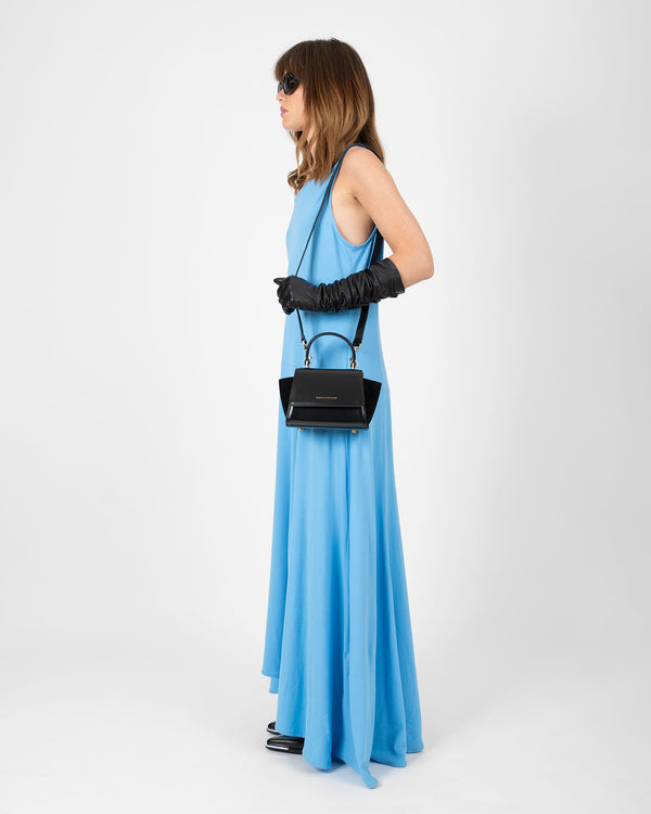 Sac ALEXIA NANO noir porté en bandoulière, vue de profil sur mannequin en robe bleue