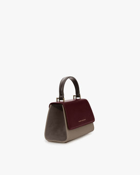 Sac ALEXIA NANO Colourblock Stratum, vue de trois quarts, poignée rigide, rabat bordeaux et flancs taupe