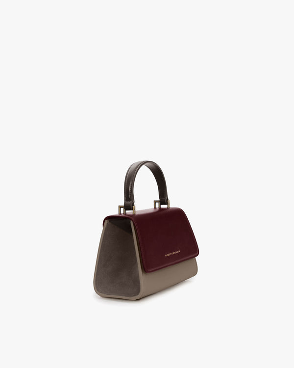 Sac ALEXIA NANO Colourblock Stratum, vue de trois quarts, poignée rigide, rabat bordeaux et flancs taupe