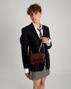 Sac ALEXIA NANO Mahogany porté en bandoulière, vue de face sur une mannequin