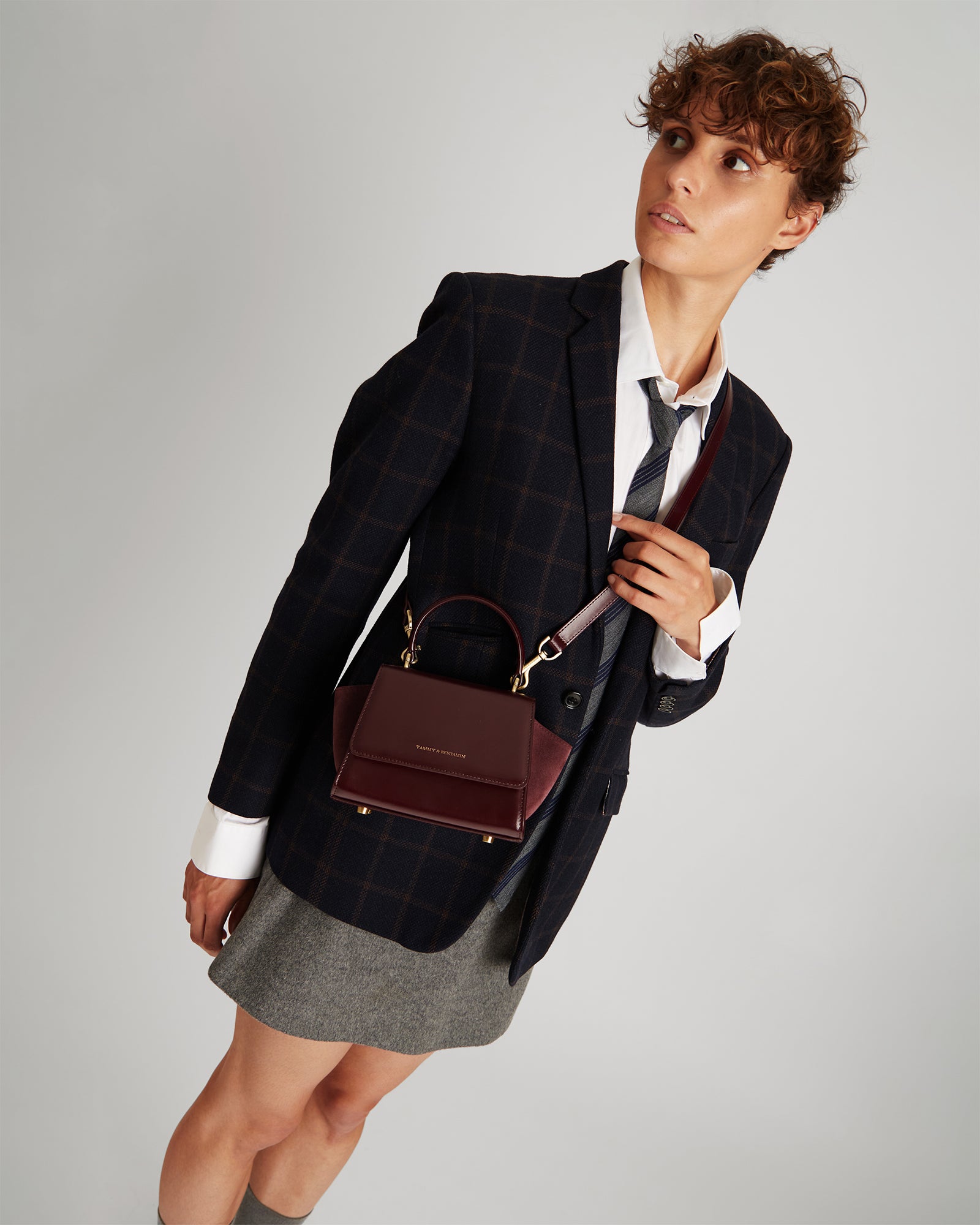 Sac ALEXIA NANO Mahogany porté en bandoulière, poignée tenue à la main, logo visible de face