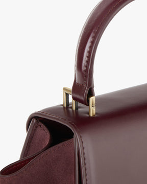 Sac ALEXIA NANO Mahogany, détail de la poignée et de l'attache en métal doré