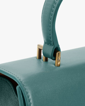 Sac ALEXIA Turquoise, détail de la poignée gainée et des fixations en métal doré vieilli sur le rabat