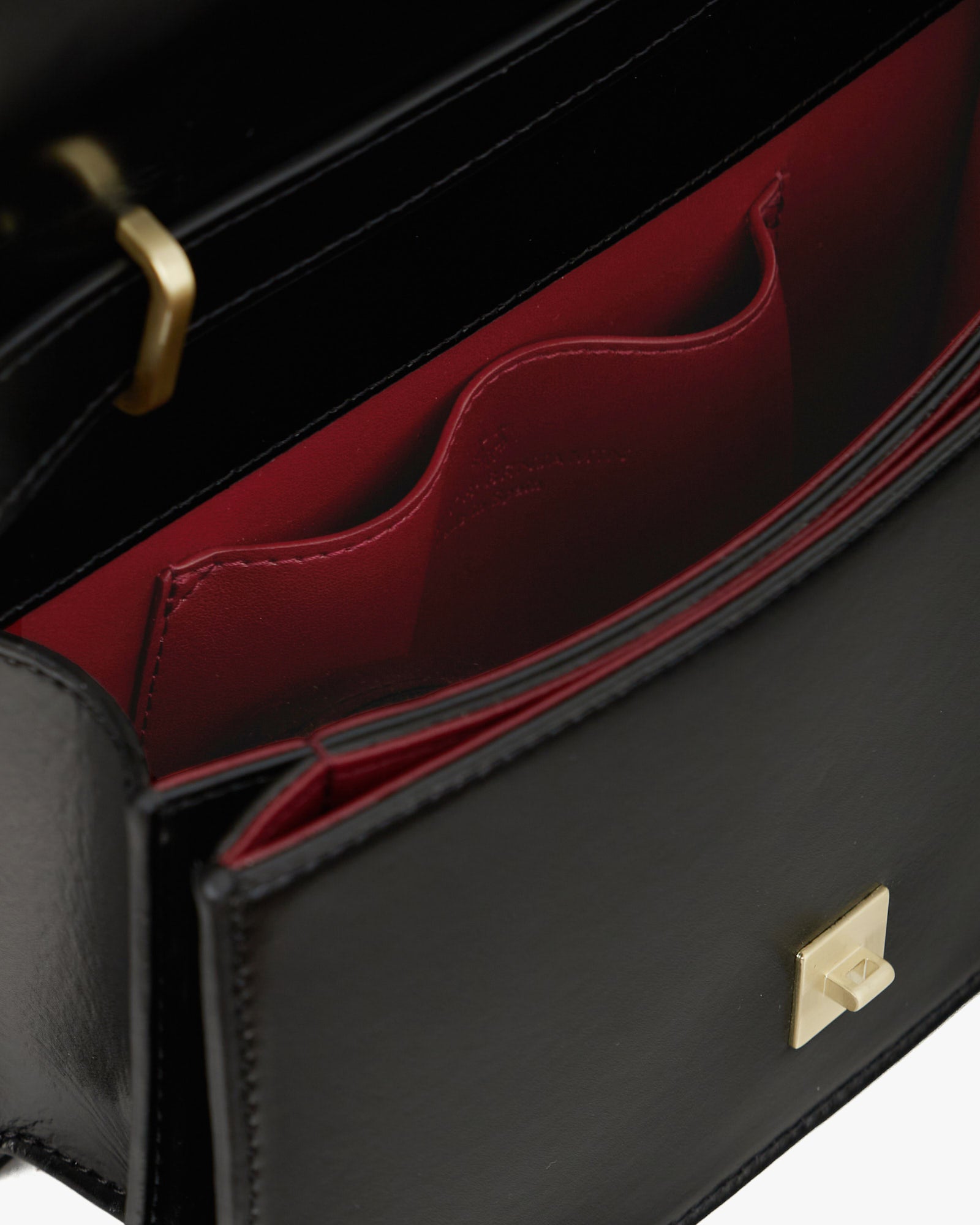 BLAKE bag in Black, open interior view with red lining, flat pocket and gold clasp