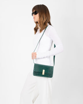 Sac BLAKE vert embossé crocodile, porté en bandoulière, vue de profil sur une mannequin