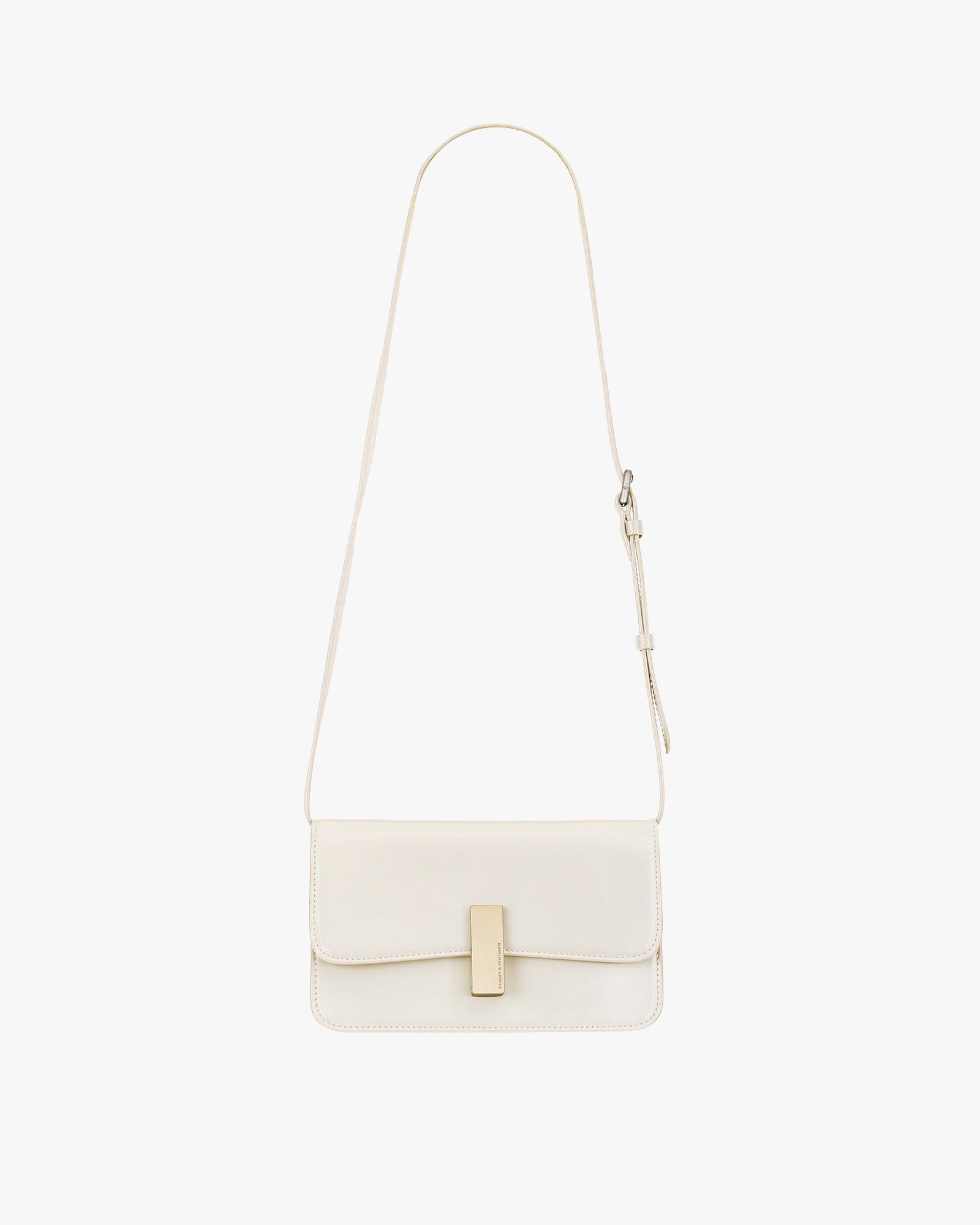 Sac BLAKE ivoire de face, bandoulière fine ajustable, fermoir rectangulaire doré, posé sur fond blanc