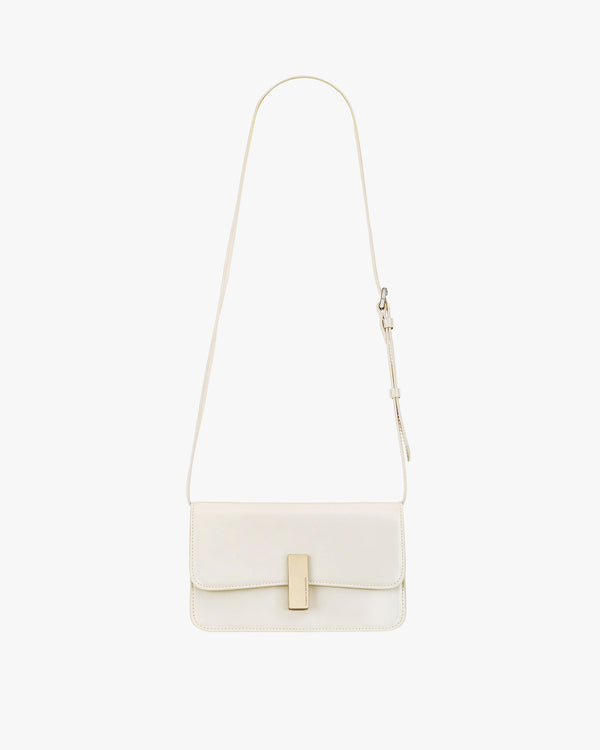 Sac BLAKE ivoire de face, bandoulière fine ajustable, fermoir rectangulaire doré, posé sur fond blanc