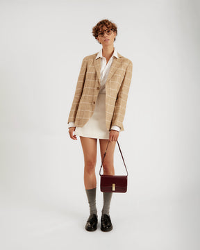 Sac BLAKE Mahogany porté en bandoulière, vue de face sur mannequin, tenue blazer et jupe