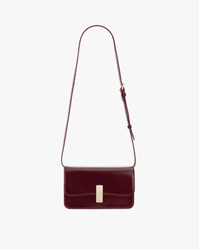 Sac BLAKE Mahogany de face, posé, fermoir doré et bandoulière fine ajustable déployée