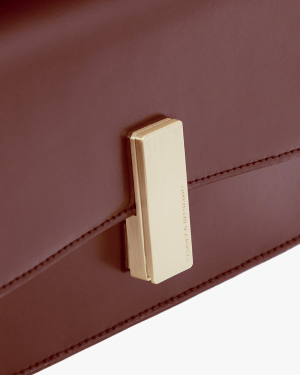 Sac BLAKE Mahogany, gros plan sur le fermoir doré gravé et les coutures du rabat