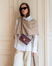 ELEANOR bag in Aubergine worn crossbody, gold Marble Arch clasp, styled with beige and white outfit