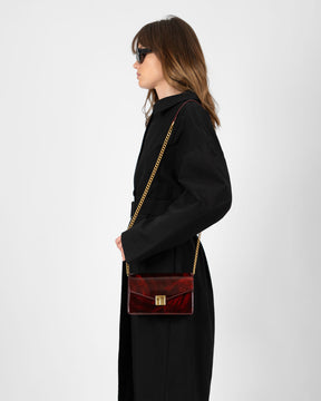 Sac ELEANOR Marbre porté en bandoulière avec chaîne dorée, vue de profil