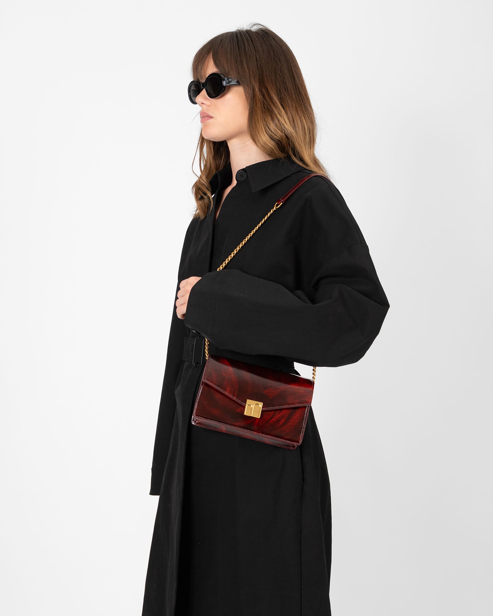 Sac ELEANOR Marbre porté en bandoulière avec chaîne dorée, vue de profil, fermoir Marble Arch visible