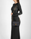 ELEANOR bag in black monogram worn crossbody with gold chain, side view
