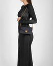 ELEANOR Black monogram bag worn on the shoulder with chain strap, side view on a model