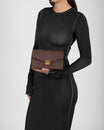 ELEANOR bag in Chocolate monogram, held in hand, front view of the gold Marble Arch clasp