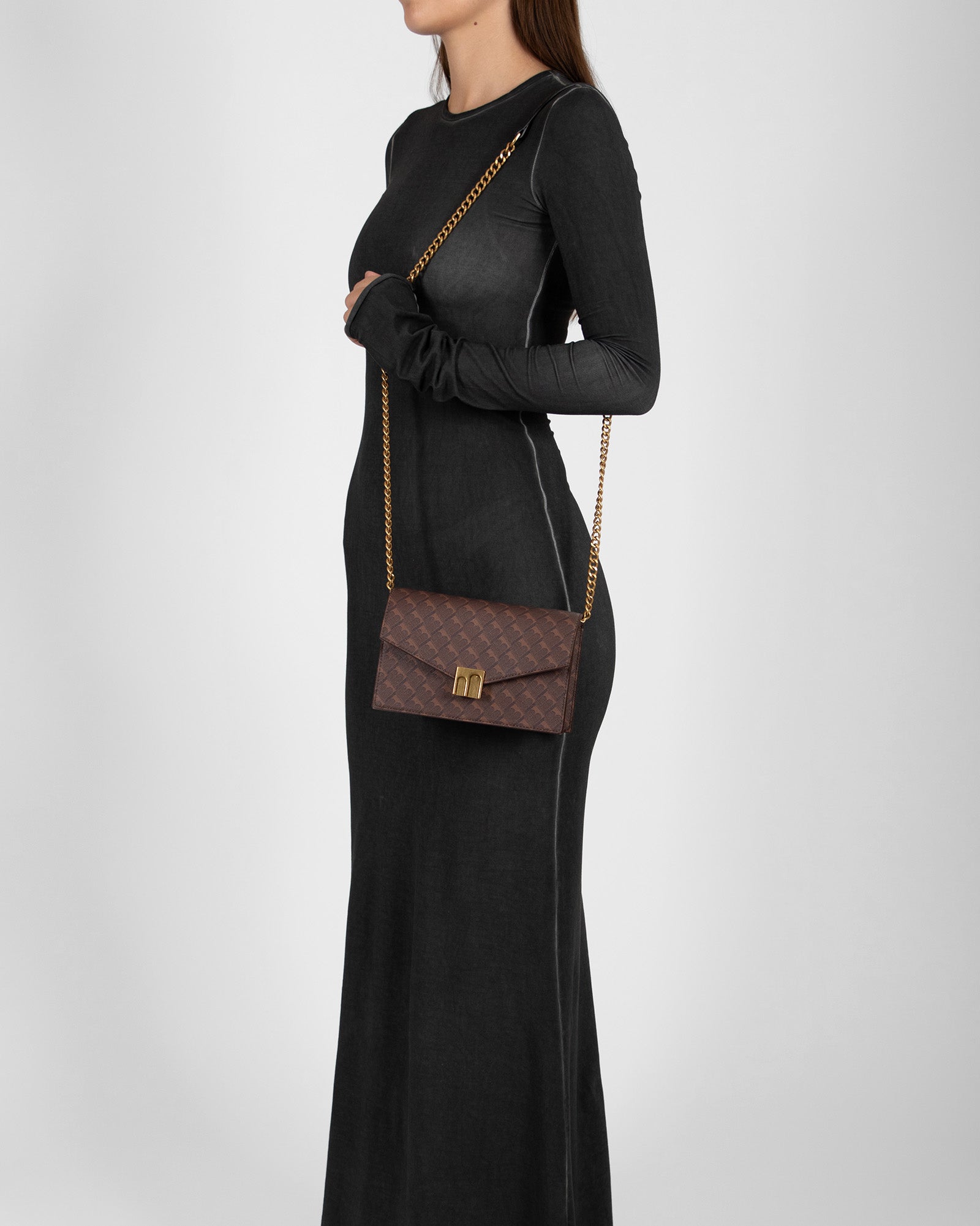 ELEANOR bag in Chocolate monogram worn crossbody with chain strap, side view