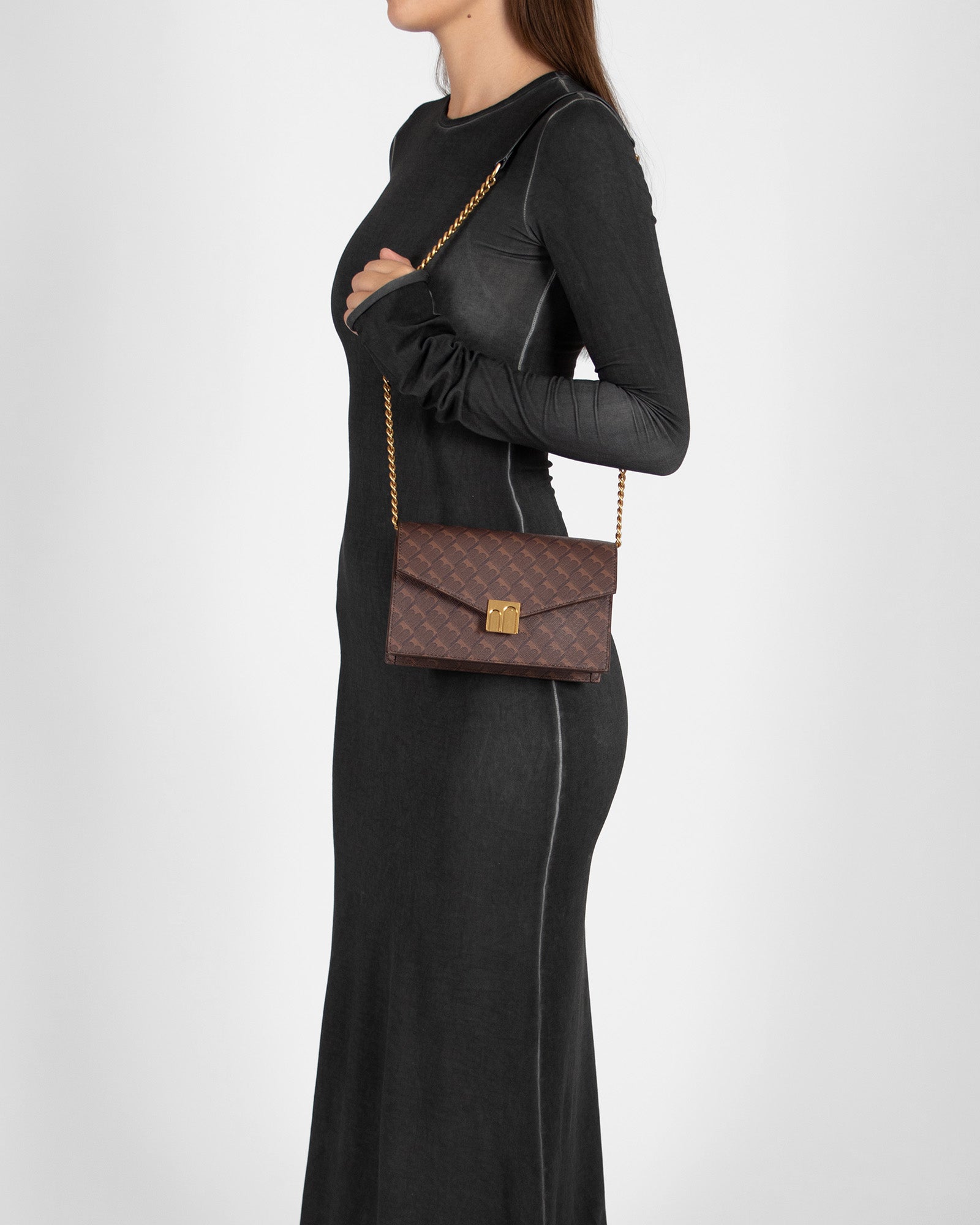 ELEANOR bag in Chocolat monogram worn on the shoulder with chain, side view on model