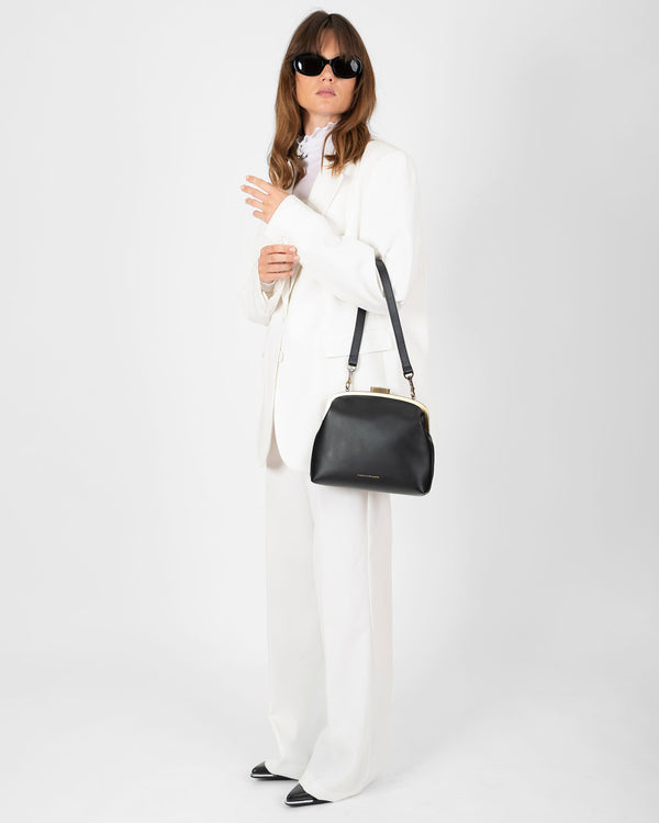 Sac EMMA Noir porté à l'épaule avec bandoulière, vue de face en pied sur mannequin